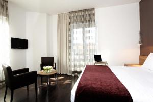 a hotel room with a large bed and two chairs at Citiz Hotel in Toulouse