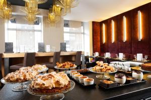 a table with many different types of food on it at Citiz Hotel in Toulouse