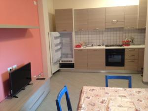 a kitchen with a table and two chairs and a television at Alba Adriatica Olimpica in Alba Adriatica