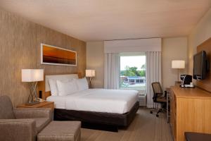 Holiday Inn Little Rock - Presidential Downtown, an IHG Hotel في ليتل روك: غرفه فندقيه بسرير ونافذه