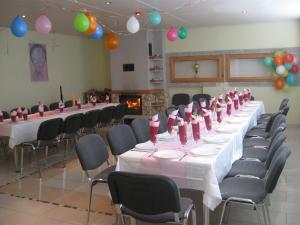 a long table in a room with chairs and balloons at Penzión BREJK in Liptovské Sliače