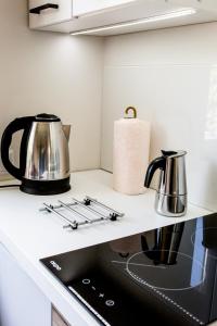 a kitchen counter with a stove and a tea kettle at Apartament Mrągowo in Mrągowo