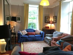a living room with two blue couches and a window at The Old Monastery Guesthouse in Cahersiveen