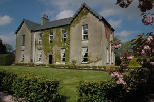 a large brick house with ivy growing on it at The Old Monastery Guesthouse in Cahersiveen