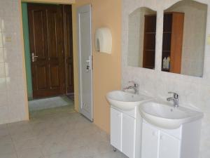 a bathroom with two sinks and a mirror and a door at Centre Hostel in Mukacheve