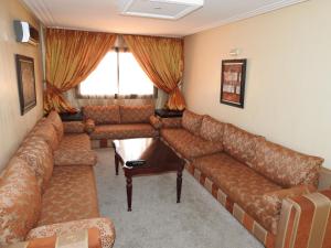 a living room with a couch and a table at Résidence Vladimiro Ariano in Laayoune