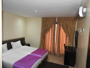 a bedroom with a bed and a tv and a window at Résidence Vladimiro Ariano in Laayoune