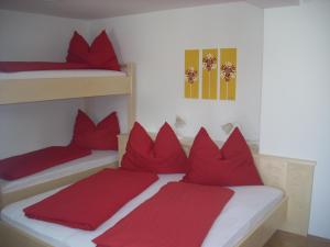 エーベン・イム・ポンガウにあるSimonlehengutの赤い枕のベッド2台が備わる客室です。
