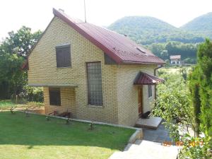 una pequeña casa amarilla con techo rojo en Holiday Home Zbilje, en Visoko