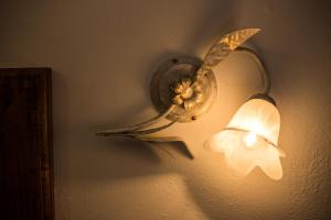 a light on a wall with a flower on it at Villa il Poderino in Marina di Campo