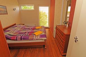 ein Schlafzimmer mit einem Bett, einer Kommode und einem Fenster in der Unterkunft Ringi 37 Apartment in Pärnu