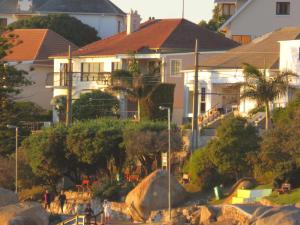 een huis op een heuvel met huizen op de achtergrond bij On-the-Rocks in Fish hoek