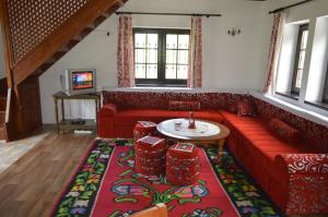a living room with a red couch and a table at Apartment Holiday - River view beside Pyramid in Visoko