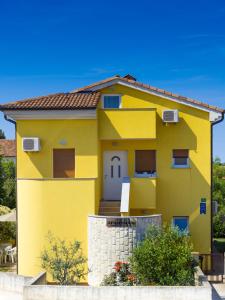 una casa amarilla con una puerta blanca en Apartments Manuela, en Pula