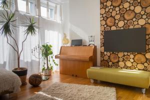 a living room with a tv and a piano at Feriendomizil "Alte Post" I in Pronsfeld