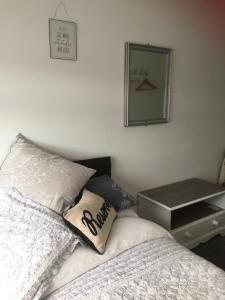 1 dormitorio con cama y espejo en la pared en Southend Airport Bed & Breakfast, en Rochford