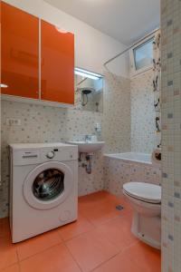 a bathroom with a washing machine and a toilet at Beach Apartment Lana in Split