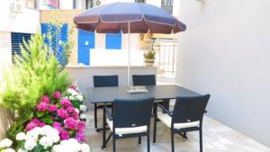 een tafel en stoelen met een parasol en bloemen bij Superior Apartment CASA SPALATO in Split