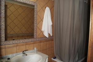 a bathroom with a sink and a shower curtain at La Alquería de Manu - venta el Laminador in Riópar +42 photos
