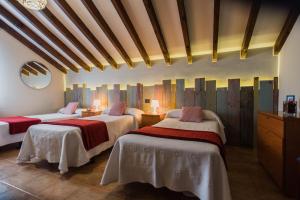 a bedroom with two beds with red and white sheets at Apartamentos River Santander in Santander