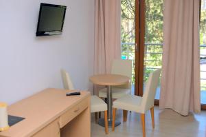 a room with a table and chairs and a table and a television at Villa Camp in Jurata