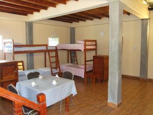 a room with three bunk beds and tables and chairs at Central City Hostel in Kandy