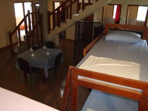 a room with two beds and a table and a staircase at Central City Hostel in Kandy