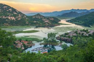 an aerial view of a river with mountains at Paradise House Skadar Lake in Karuč