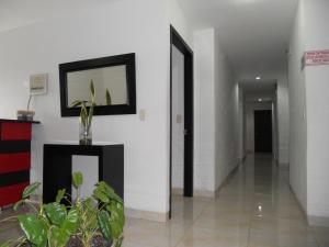 a hallway with white walls and a picture on the wall at Hotel Cosmos Sincelejo in Sincelejo