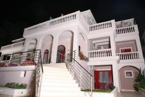 uma casa branca com escadas em frente em Michaelangelo em Parga