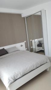 ママイアにあるLe Reve Apartment Mamaia Nordのベッドルーム(白いベッド1台、鏡付)