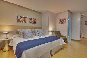 ラスパルマス・デ・グランカナリアにあるChic-Housing Las Canterasのベッドルーム(大型ベッド1台、椅子付)