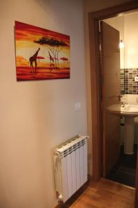 a bathroom with a painting of giraffes on the wall at Alojamiento Losillas 2 in Avila