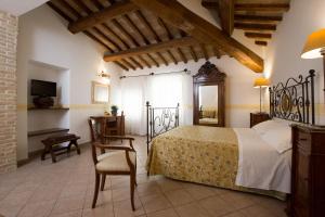 a bedroom with a bed and a table and a chair at Hotel Palazzo Brunamonti in Bevagna