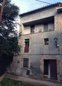 - un vieux bâtiment en pierre avec des fenêtres et un balcon dans l'établissement Cal Son, à Alpens
