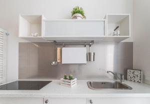 a kitchen with white cabinets and a sink at Incentro in Gallipoli +47 photos