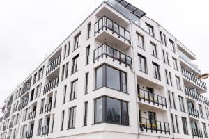 a white building with black balconies on it at Hafenapartments Warnemünde in Warnemünde