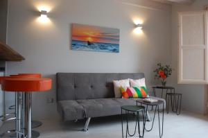ein Wohnzimmer mit einem Sofa, einem Tisch und Stühlen in der Unterkunft Apartamentos La Harinera in Torres de Albarracín