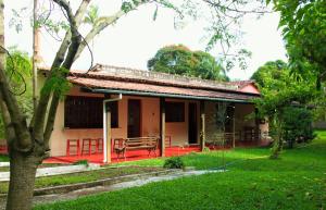 聖克魯斯迪米納斯的住宿－Sitio Estrada Real de Tirandentes，一座带红色门廊和绿色庭院的房子