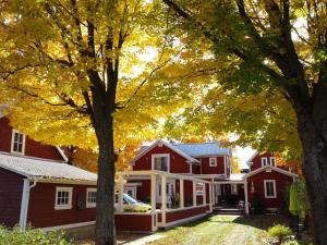 a red house with trees in front of it at Le Gîte Du Coteau in Lyster