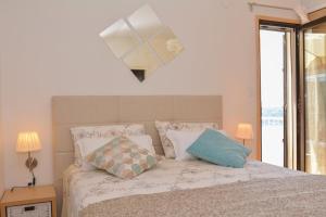 a bedroom with a bed with pillows and a mirror at Apartment and room Sveti Jakov in Dubrovnik