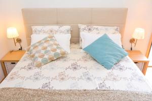 a bed with two pillows on it with two lamps at Apartment and room Sveti Jakov in Dubrovnik