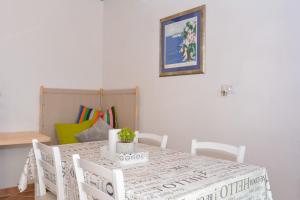 a dining room with a table with chairs and a picture at Apartment and room Sveti Jakov in Dubrovnik