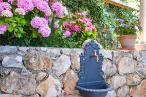 a blue bird mailbox on a stone wall with flowers at Apartment and room Sveti Jakov in Dubrovnik
