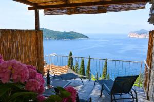 a balcony with tables and chairs and a view of the ocean at Apartment and room Sveti Jakov in Dubrovnik