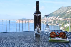 a table with a bottle of wine and glasses on it at Apartment and room Sveti Jakov in Dubrovnik