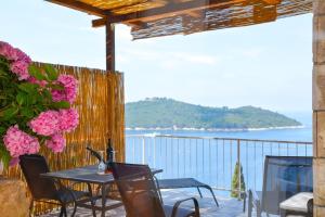 a table and chairs on a balcony with a view of the ocean at Apartment and room Sveti Jakov in Dubrovnik