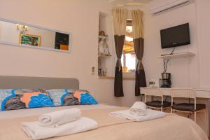 a bedroom with a bed and a television and a table at Apartment and room Sveti Jakov in Dubrovnik