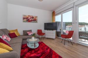 a living room with a couch and a tv at Apartments Radica in Podstrana