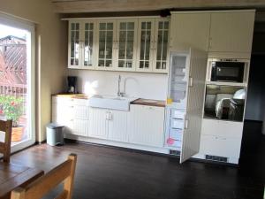 a kitchen with white cabinets and a sink at Ferienhaus Suhr in Wittmund
